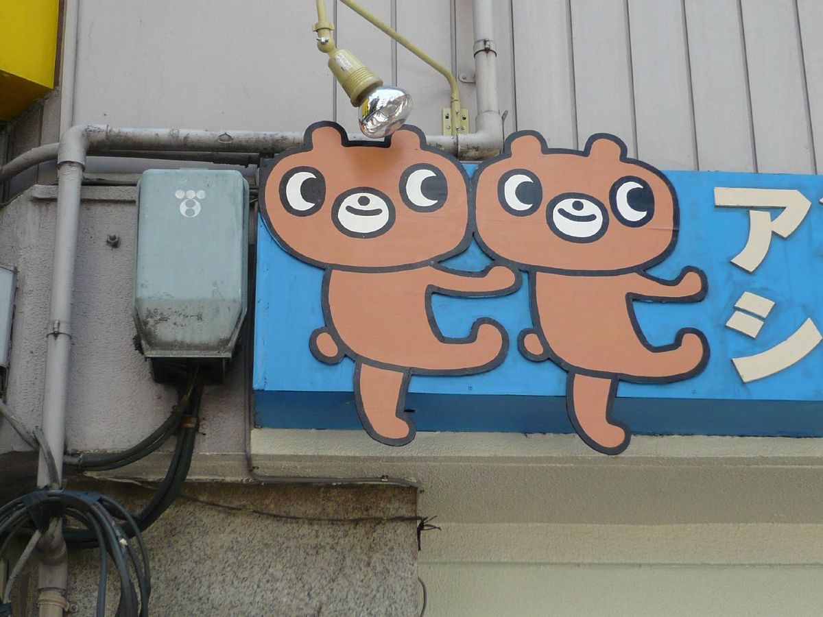 파란 간판 위의 갈색 곰 캐릭터 둘